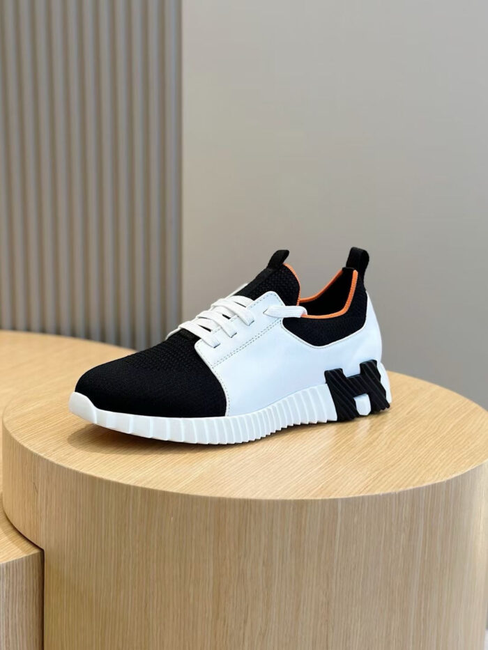Sneaker moderna bianca e nera su pedestallo in legno, design elegante e comfort sportivo.