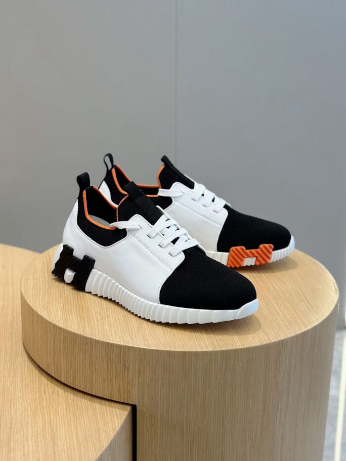 Scarpe sportive moderne con dettagli arancioni e design trendy su piattaforma di legno