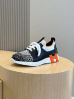 Scarpa sneakers moderna con dettagli colorati e design trendy su piedistallo di legno naturale.