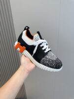 Sneaker moderna nera, bianca e arancione, comfort e stile per urban fitness.