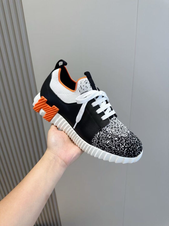 Sneaker moderna nera, bianca e arancione, comfort e stile per urban fitness.