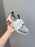 Sneaker sportiva moderna con dettagli arancioni, design leggero e supporto in comfort e stile.