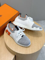 Sneakers eleganti con dettagli arancio, su piattaforma di legno, stile moderno e sneakers di tendenza