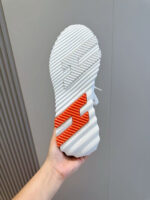 Sole di sneaker moderna con dettagli bianchi e accento arancione per stile e comfort specifico.
