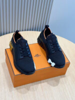 Sneakers nere moderne con dettagli arancioni, su superficie in legno e sfondo minimalista elegante.