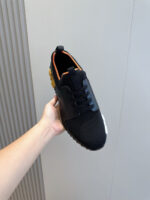 Sneaker nera moderna con dettagli arancione e suola antiscivolo, leggera e sportiva.