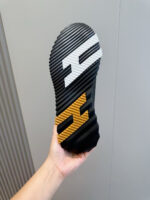 Sola di scarpe sportive con logo bianco e arancione, design moderno e texture antiscivolo.