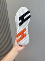 Suola sneaker bianca con loghi moderni e design sportivo, vista ravvicinata.