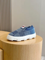 Sneaker blu senza lacci, suola bianca moderna, design confortevole e stile urbano.