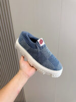 Sneaker slip-on in tessuto blu, suola spessa e logo rosso, perfetta per look casual e sporty.