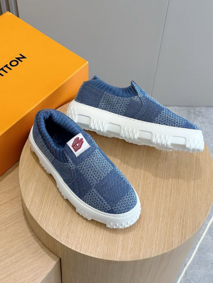 Sneakers slip-on blu con suola chunky e scatola arancione, stile moderno e sportivo.