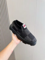Sneaker nera moderna con suola antiscivolo e dettagli rossi, leggera e perfetta per stile e comfort.