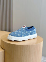 Sneaker moda blu con suola bianca e dettagli di lusso su supporto in legno.