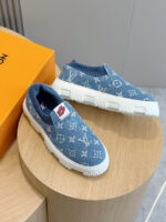 Sneakers di lusso blu in maglia, design casual elegante con dettaglio rosso.