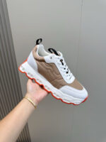 Sneaker moderna bianca e marrone con suola arancione, stile casual e sportivo, perfetta per ogni occasione.