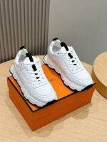 Sneakers bianche moderne su scatola arancione, stile casual e trendy per outfit sportivi.