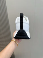 Sneaker bianca con dettagli neri e tallone rinforzato, stile moderno e comfort elegante.