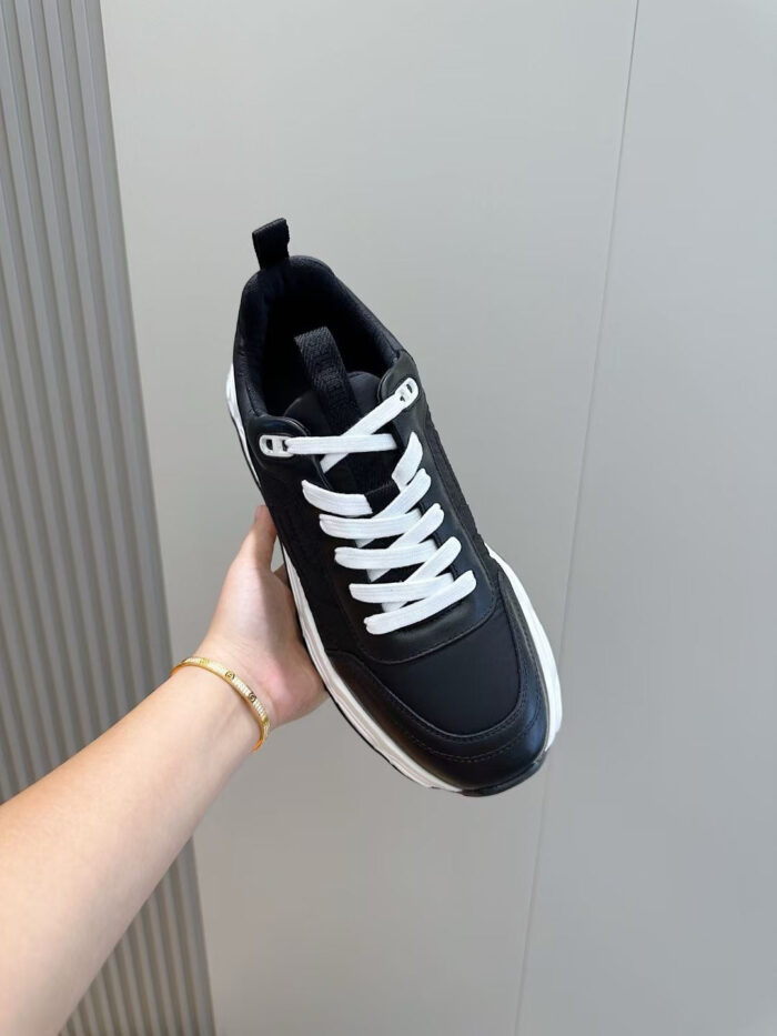 Sneaker nera moderna con lacci bianchi, design trendy e dettagli di stile per ogni occasione.