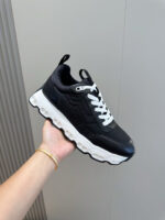 Sneaker nera moderna con suola spessa e lacci bianchi per stile e comfort urbano.