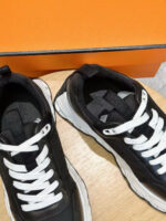 Scarpe sportive nere con dettagli bianchi e scatola arancione, stile moderno e alla moda.