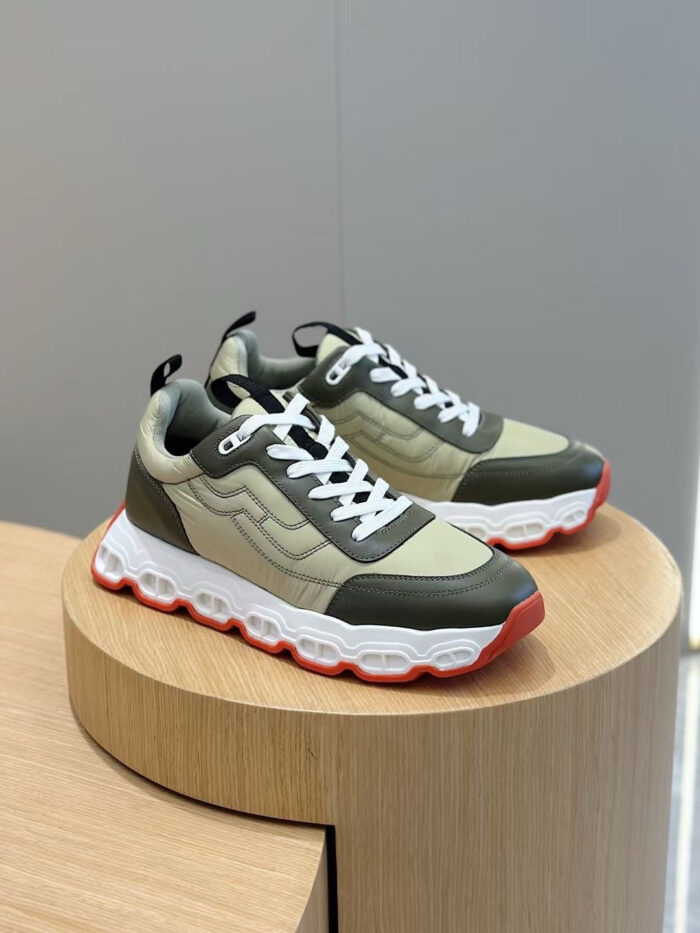 Sneakers moderne verde e crema con suola a contrasto su supporto in legno.