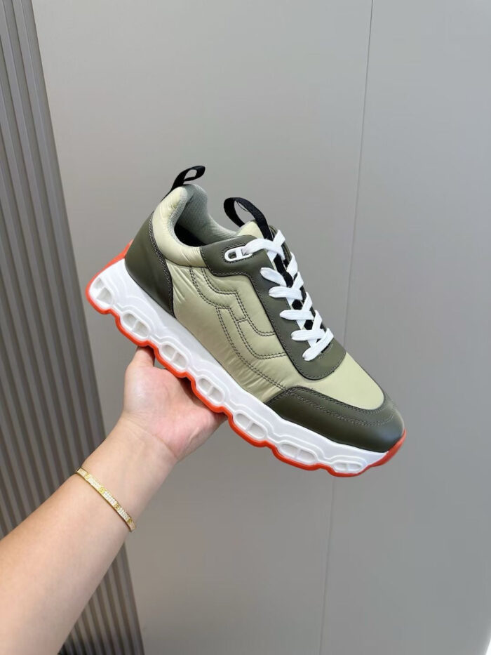 Sneaker moderna verde e crema con dettagli arancioni, stile sportivo e comfort elevato.