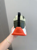 Sneaker Hermes da uomo con dettagli arancioni, stile moderno e design elegante.