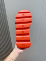Suola sportiva arancione con scanalature antiscivolo e design ergonomico per comfort e performance