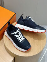 Sneakers navy moderne con dettagli colorati, su piedistallo in legno, sfondo arancione elegante.