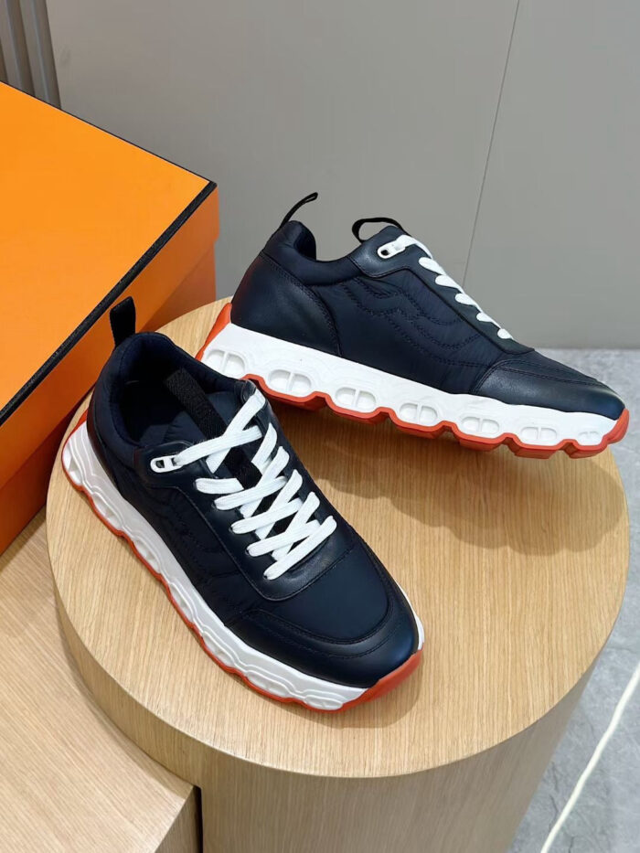 Sneakers navy moderne con dettagli colorati, su piedistallo in legno, sfondo arancione elegante.