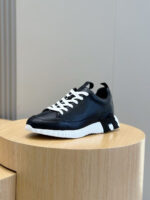 Sneaker in pelle nera con lacci bianchi, suola bianca testurizzata, stile elegante e sportivo.