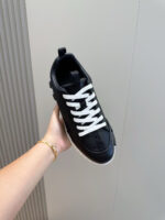 Sneaker nera moderna con suola bianca, stile minimalista e versatile, in primo piano.