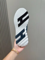 Sole di sneakers bianco con logo nero e grip antiscivolo, dettagli moderni e design sportivo.