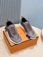 Sneakers di lusso marroni e bianche su scatola arancione, stile elegante e design sofisticato.