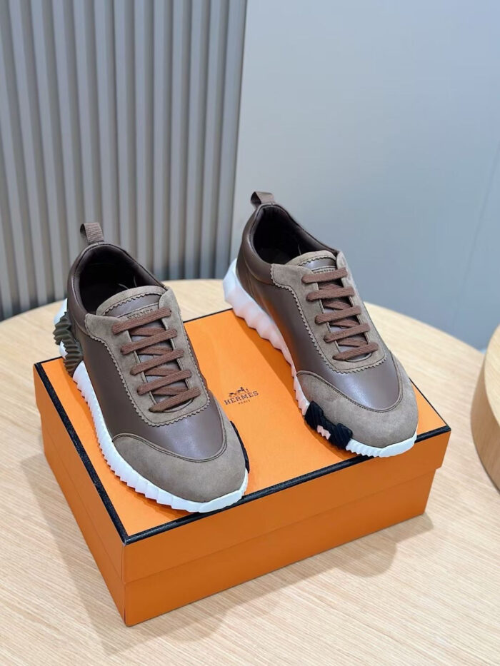 Sneakers di lusso marroni e bianche su scatola arancione, stile elegante e design sofisticato.