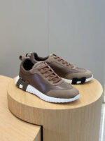 Scarpe da ginnastica morbide in marrone su pedana di legno, stile moderno ed elegante.