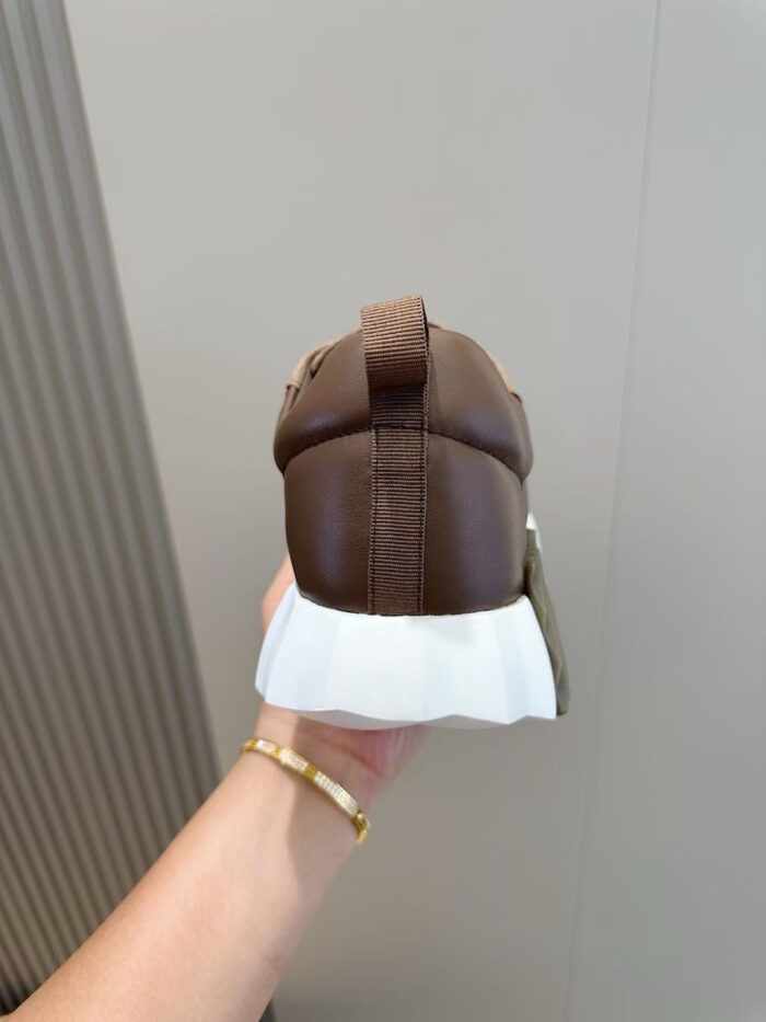 Sneaker in pelle marrone con suola bianca, design elegante e comfort per ogni occasione.