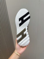 Suola di scarpa moderna con logo, disegno dinamico e grip antiscivolo, tenuta a mano.