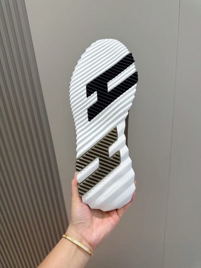 Suola di scarpa moderna con logo, disegno dinamico e grip antiscivolo, tenuta a mano.