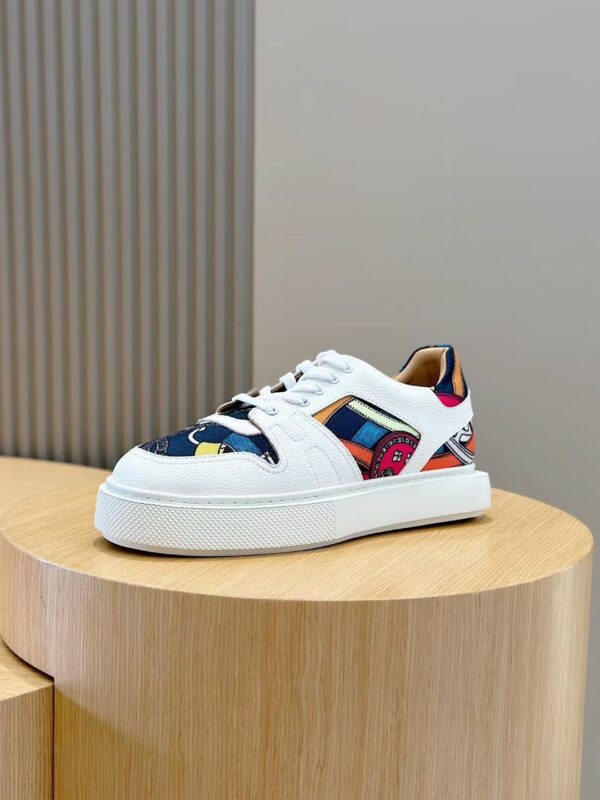 Sneaker moderna con dettagli colorati e suola spessa su pedestal di legno.