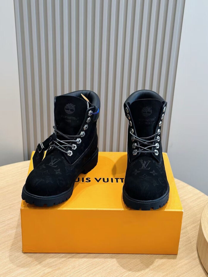 Stivali neri di lusso Louis Vuitton su scatola arancione, stile robusto e elegante.