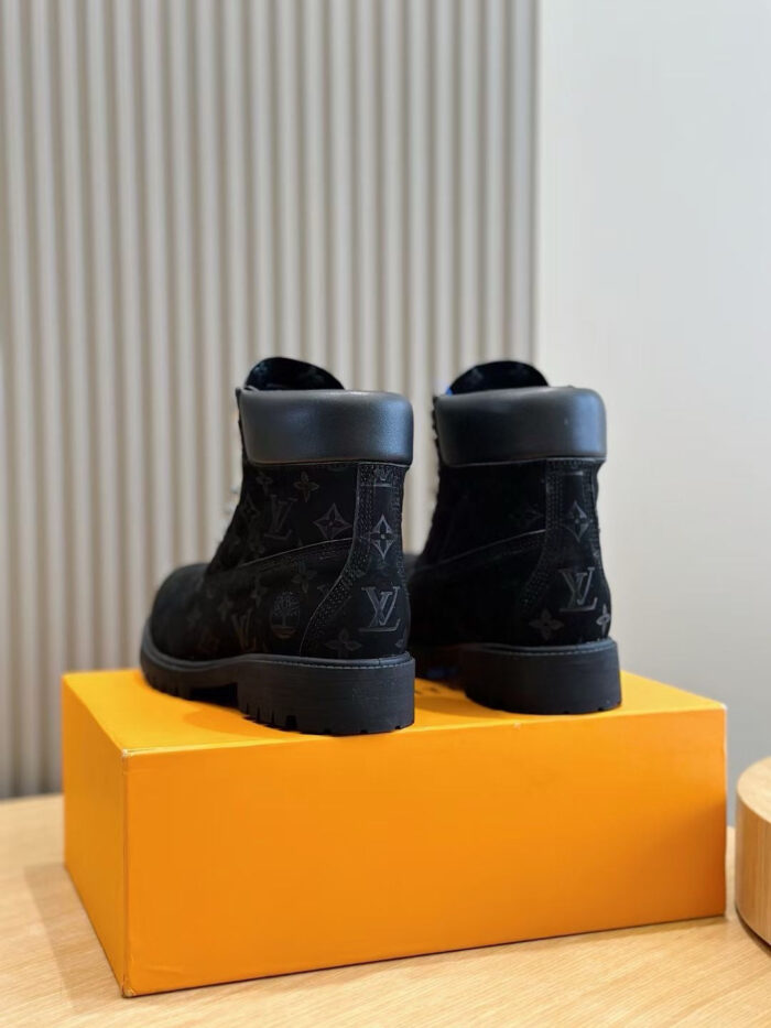 Stivali neri in suede eleganti su scatola arancione, stile minimalista e dettagli di lusso.
