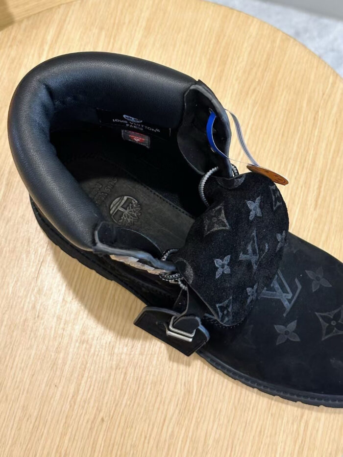 Stivale nero di lusso in pelle e suede con monogramma iconico, perfetto per eleganza e comfort.