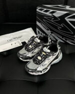 Sneakers Off-White moderne con design artistico e packaging elegante su sfondo nero.