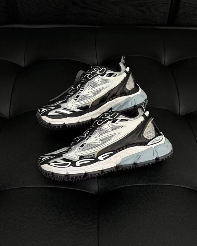 Sneakers futuristiche nere e bianche su sfondo elegante, stile moderno e design innovativo.