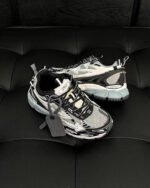 Sneakers moderne premium nero e bianco con suola chunky e dettagli innovativi, su sfondo elegante.
