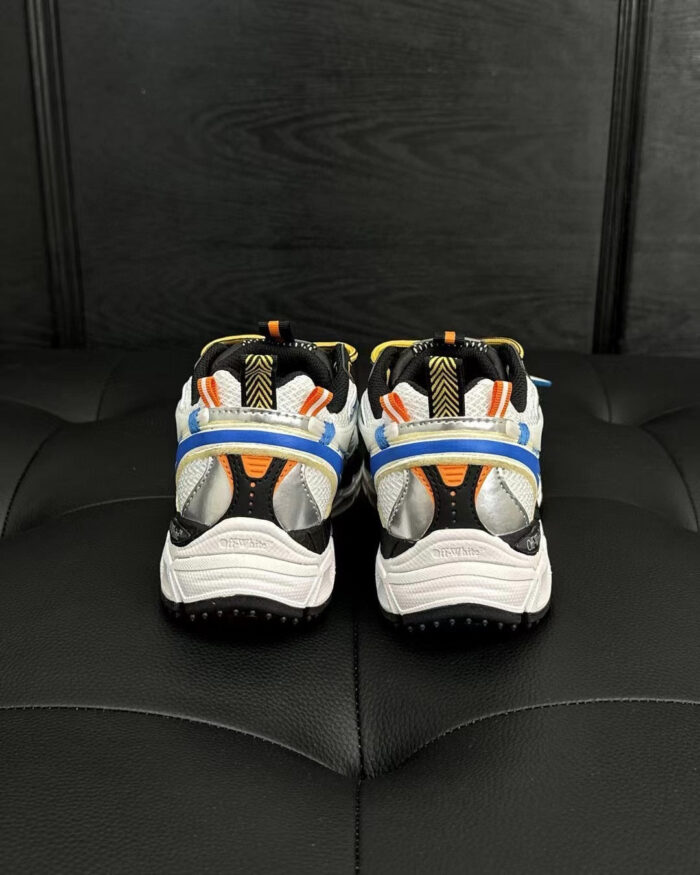Scarpe sportive bianche con dettagli arancioni e blu, design moderno e performance elevata.