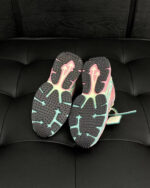 Scarpe sportive con suole colorate, design innovativo e grip ottimale su superficie in pelle nera