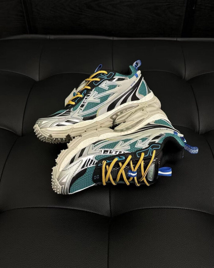 Sneakers sportive teal, bianco e giallo su superficie in pelle nera, ideali per attività e relax.