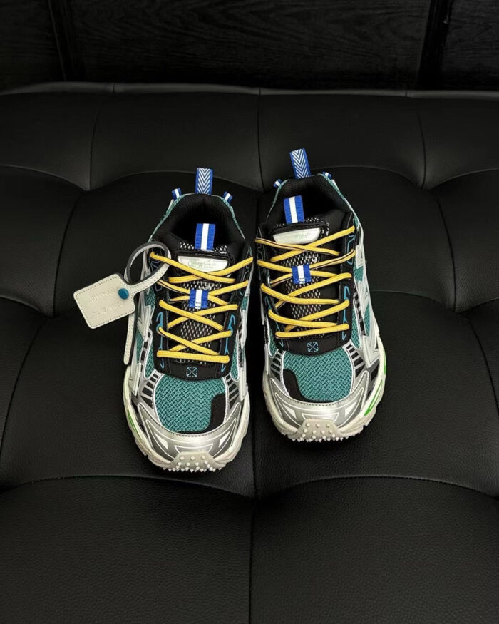 Sneakers futuristiche colorate con dettagli moderni e finiture lucide su sfondo scuro e tufted.